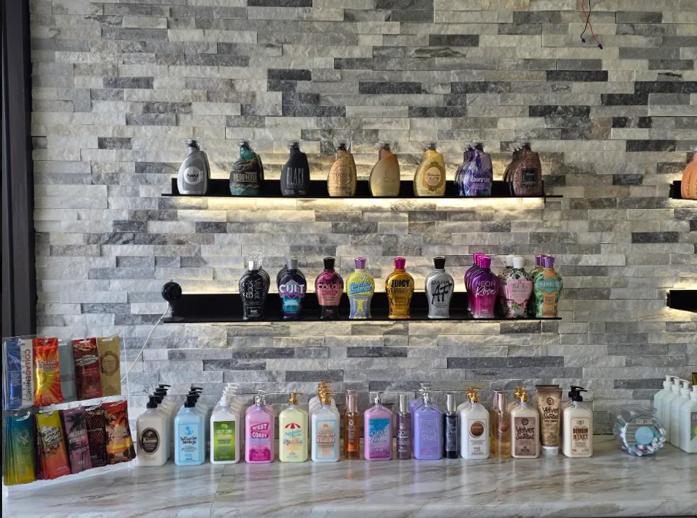 Devoted Creations tanning lotions on the stone feature wall at Sunsational Tan Bridgeville